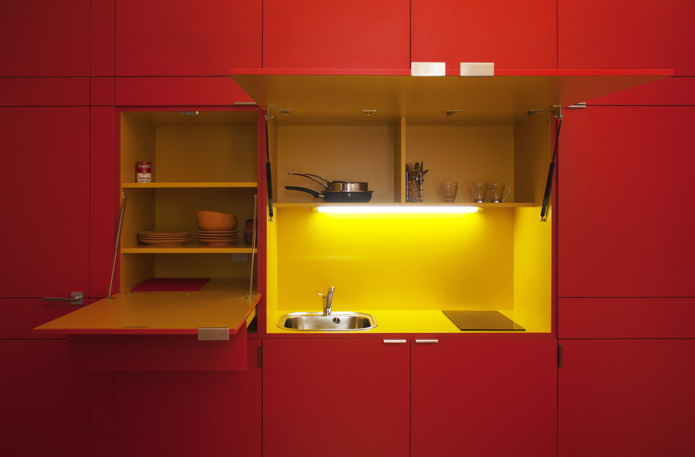 Idées déco pour une petite cuisine linéaire contemporaine fermée avec un évier 1 bac, des portes de placard rouges, une crédence jaune, aucun îlot et un plan de travail jaune.