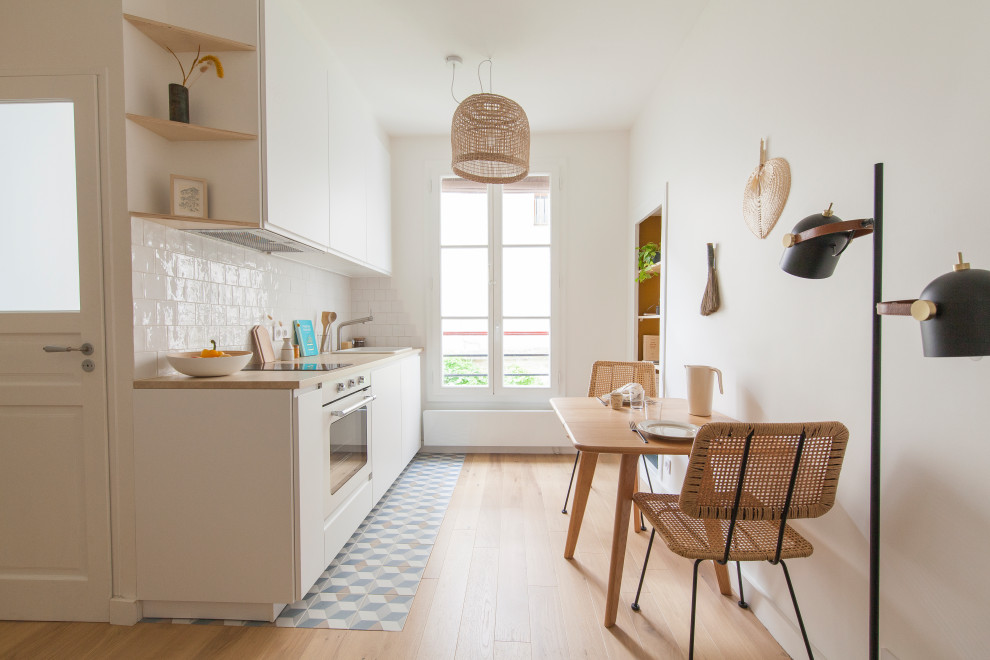 Aménagement d'une petite cuisine ouverte linéaire scandinave avec un évier 1 bac, un plan de travail en stratifié, une crédence blanche, un électroménager blanc et aucun îlot.