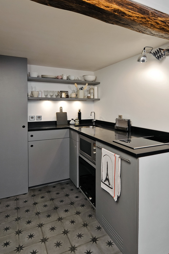 Foto di una piccola cucina contemporanea con lavello a vasca singola, paraspruzzi bianco, nessuna isola e pavimento grigio