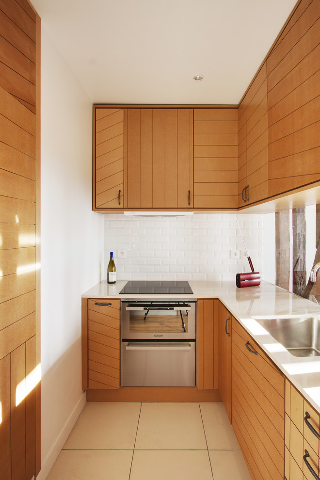 Enclosed kitchen - small contemporary galley enclosed kitchen idea in Paris with medium tone wood cabinets