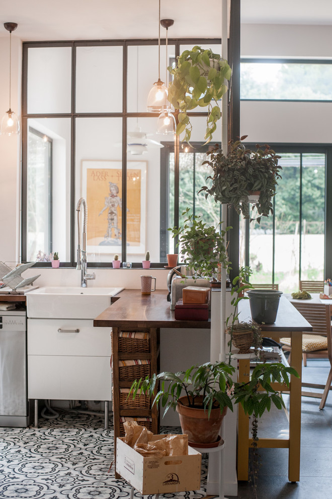 モンペリエにある高級な中くらいなインダストリアルスタイルのおしゃれなキッチン (エプロンフロントシンク、木材カウンター、白いキッチンパネル、セラミックタイルの床、アイランドなし、窓) の写真