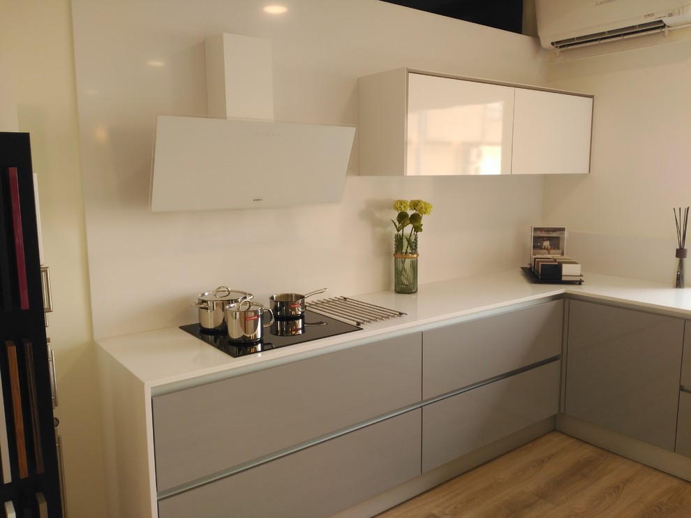 Cette image montre une cuisine minimaliste en U avec un plan de travail en quartz et un plan de travail blanc.