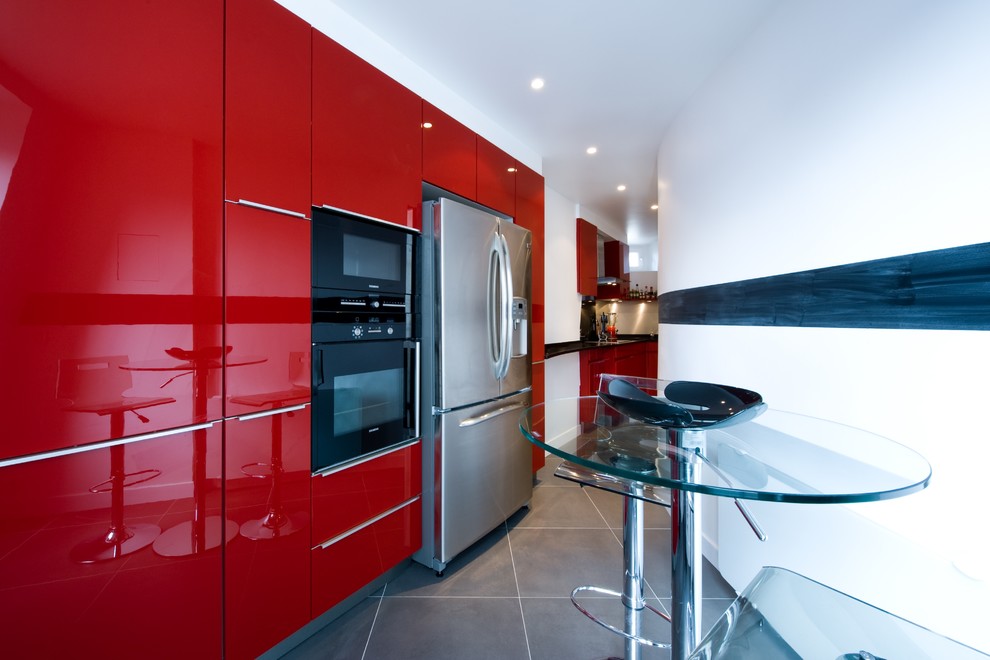 Cette photo montre une très grande cuisine linéaire moderne avec des portes de placard rouges, un plan de travail en granite et aucun îlot.