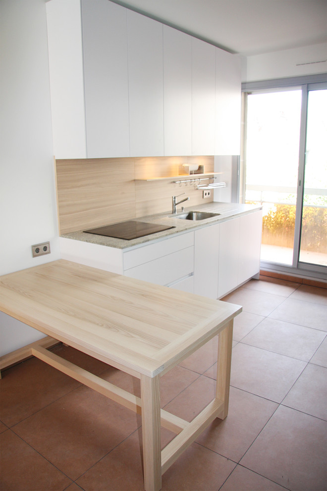 Medium sized modern single-wall open plan kitchen in Paris with a submerged sink, flat-panel cabinets, light wood cabinets, granite worktops, brown splashback, wood splashback, stainless steel appliances, terracotta flooring and a breakfast bar.