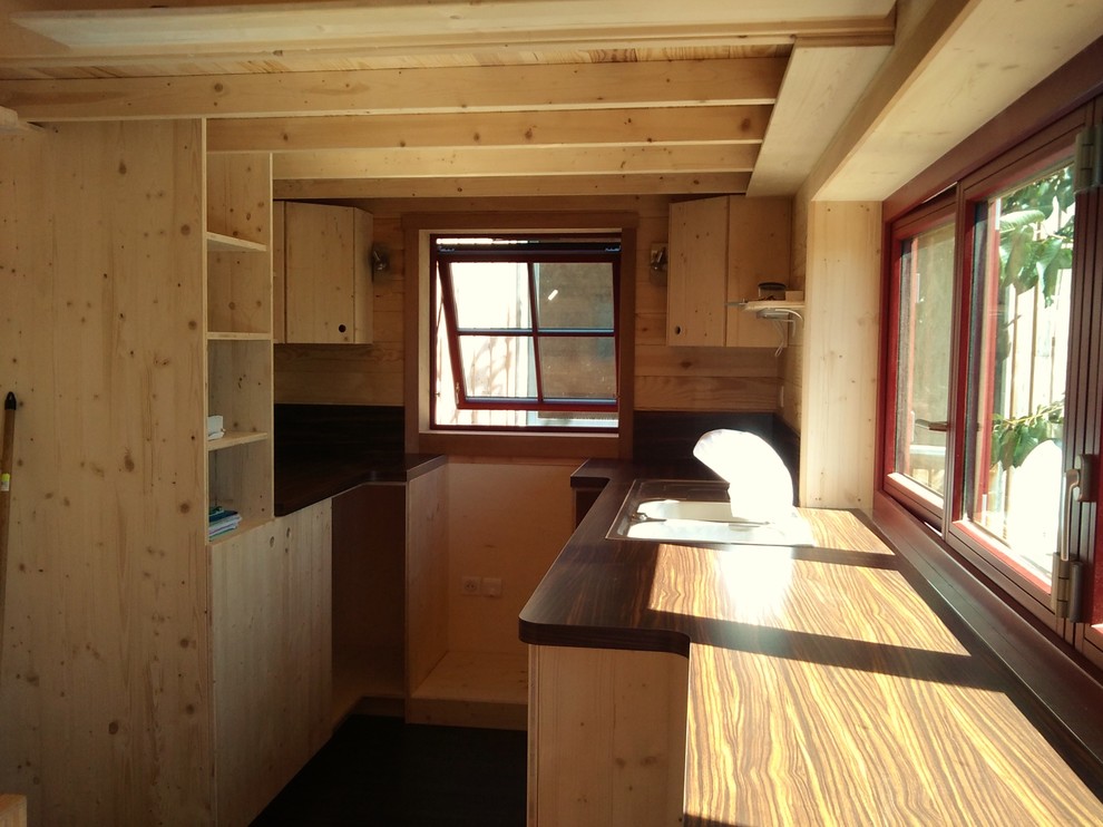 Réalisation d'une petite cuisine minimaliste en U et bois clair avec un évier 2 bacs, un placard à porte affleurante, un plan de travail en stratifié, une crédence marron et un sol en linoléum.