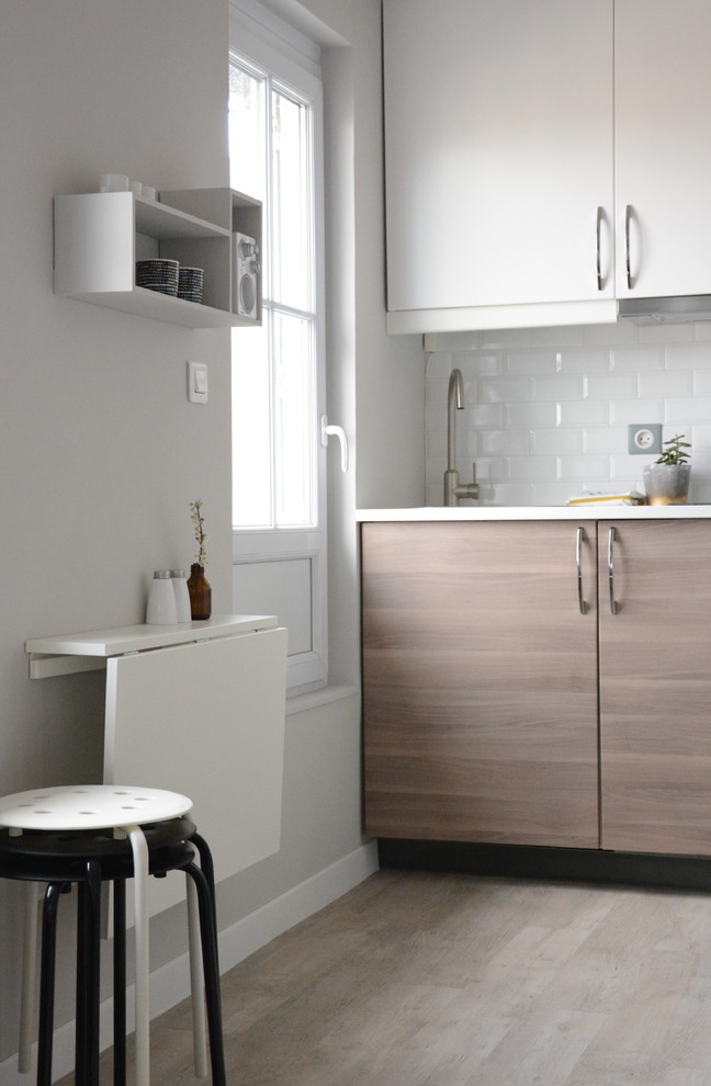 Design ideas for a small contemporary single-wall kitchen in Marseille with light wood cabinets, white splashback, metro tiled splashback and no island.