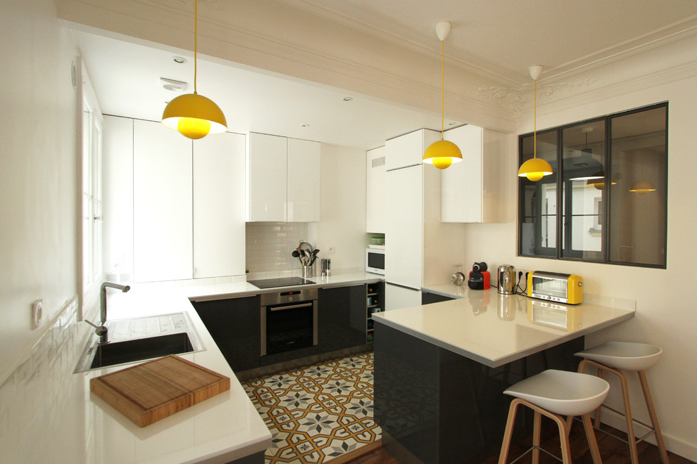 Inspiration for a medium sized contemporary l-shaped kitchen/diner in Paris with white cabinets and a breakfast bar.