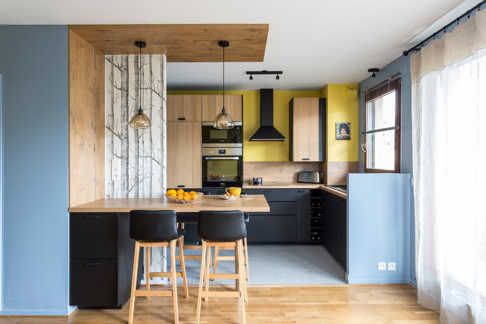Example of a mid-sized trendy l-shaped gray floor eat-in kitchen design in Paris with wood countertops, wood backsplash and an island