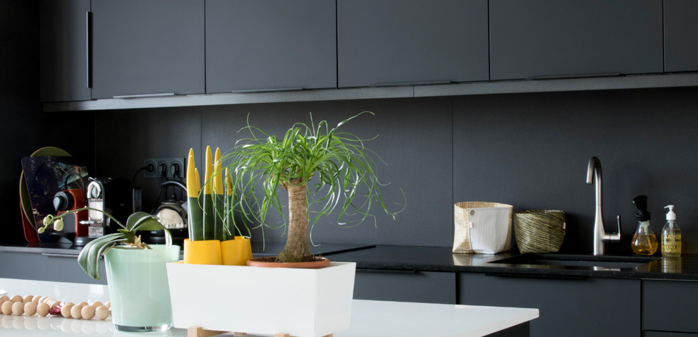 Design ideas for a large contemporary single-wall kitchen/diner in Marseille with an integrated sink, black cabinets, quartz worktops, black splashback, ceramic splashback, coloured appliances, painted wood flooring and an island.