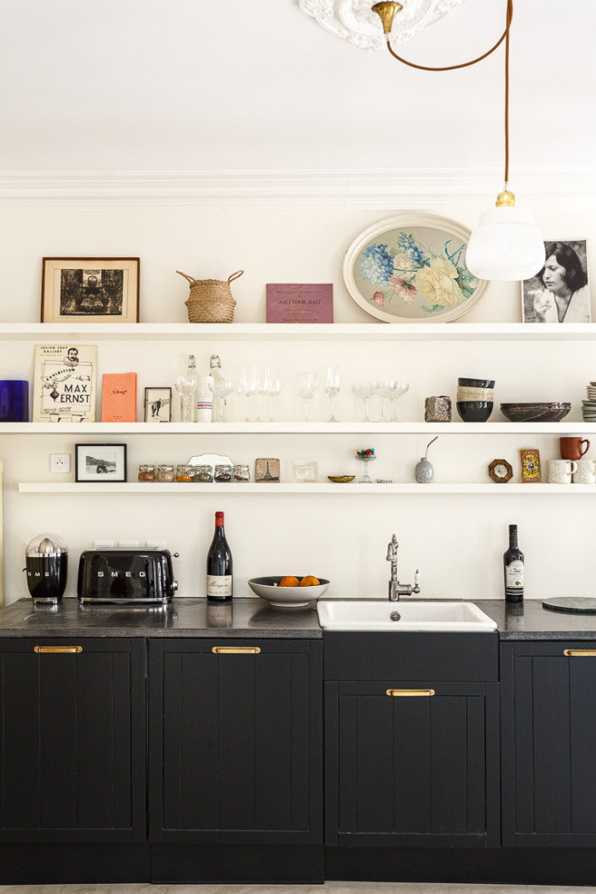 Idéer för avskilda, mellanstora vintage linjära svart kök, med en rustik diskho, luckor med infälld panel, svarta skåp, granitbänkskiva, vitt stänkskydd, svarta vitvaror, klinkergolv i keramik och grått golv