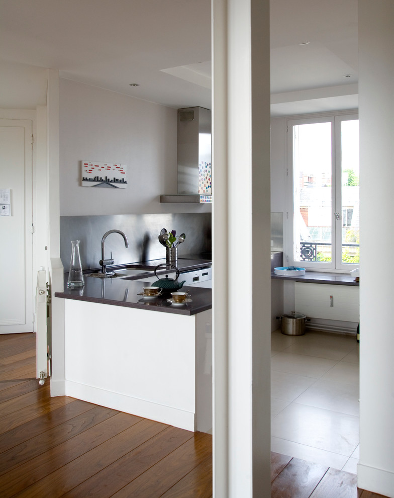Modern inredning av ett mellanstort kök, med vita skåp och en halv köksö