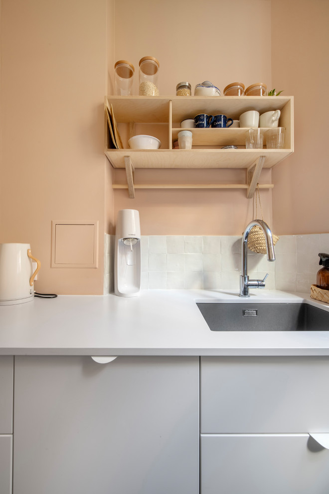 This is an example of a small vintage galley enclosed kitchen in Paris with a submerged sink, beaded cabinets, pink cabinets, quartz worktops, white splashback, terracotta splashback, integrated appliances, terrazzo flooring, no island, white floors and pink worktops.