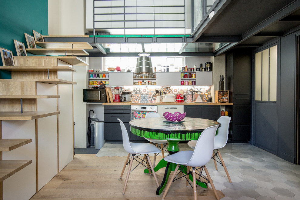 Bild på ett eklektiskt beige linjärt beige kök med öppen planlösning, med släta luckor, svarta skåp, flerfärgad stänkskydd, stänkskydd i mosaik och grått golv