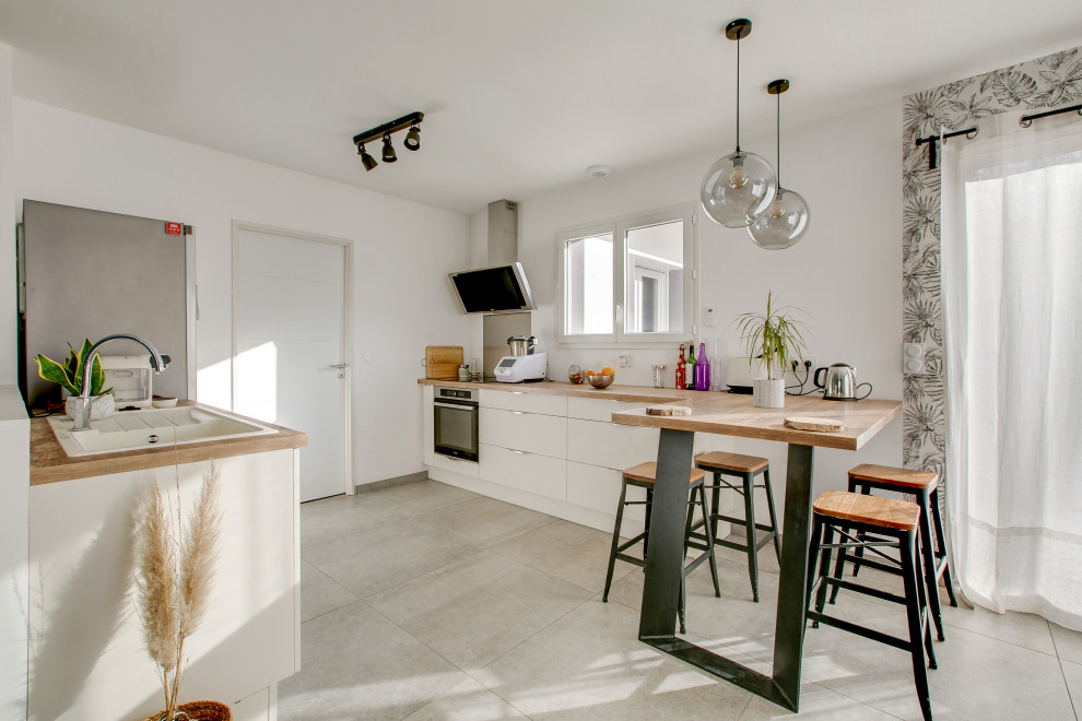 Esempio di una cucina parallela design di medie dimensioni con lavello a vasca singola, top in laminato, penisola, pavimento grigio e top marrone