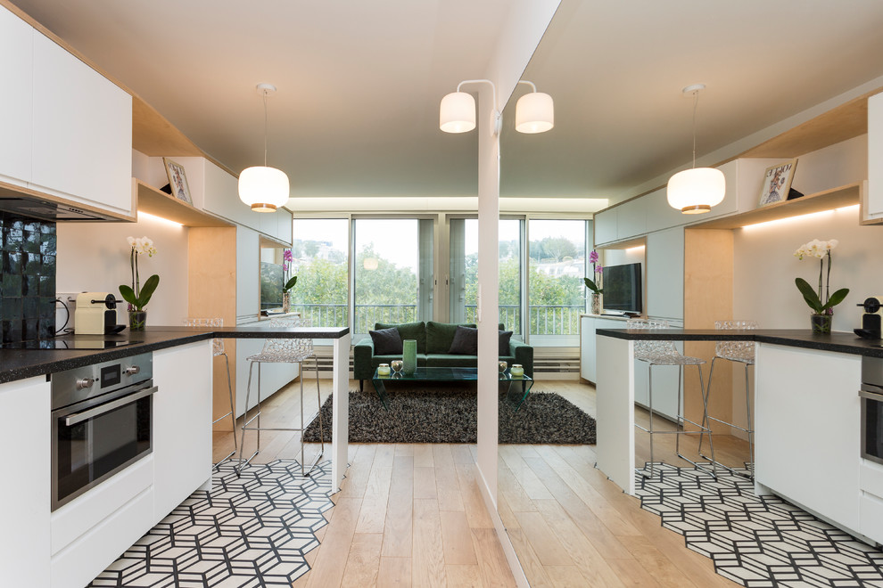 Inspiration for a small scandinavian single-wall cement tile floor and white floor open concept kitchen remodel in Paris with an undermount sink, white cabinets, laminate countertops, black backsplash, terra-cotta backsplash, paneled appliances, no island and flat-panel cabinets