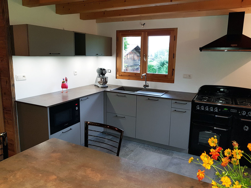 Foto di una cucina tradizionale di medie dimensioni con lavello sottopiano, ante grigie, elettrodomestici neri, pavimento in ardesia e pavimento grigio