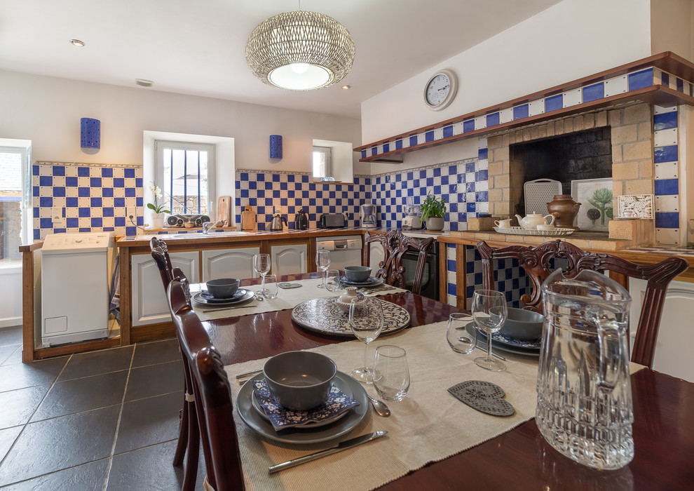 Пример оригинального дизайна: угловая кухня-гостиная среднего размера в стиле кантри с монолитной мойкой, светлыми деревянными фасадами, столешницей из плитки, синим фартуком и фартуком из плитки мозаики без острова