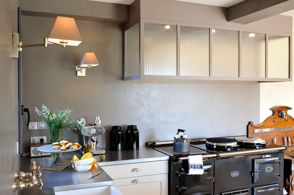 Eklektische Wohnküche ohne Insel in L-Form mit Edelstahl-Arbeitsplatte, Küchenrückwand in Grau und Küchengeräten aus Edelstahl in Rennes