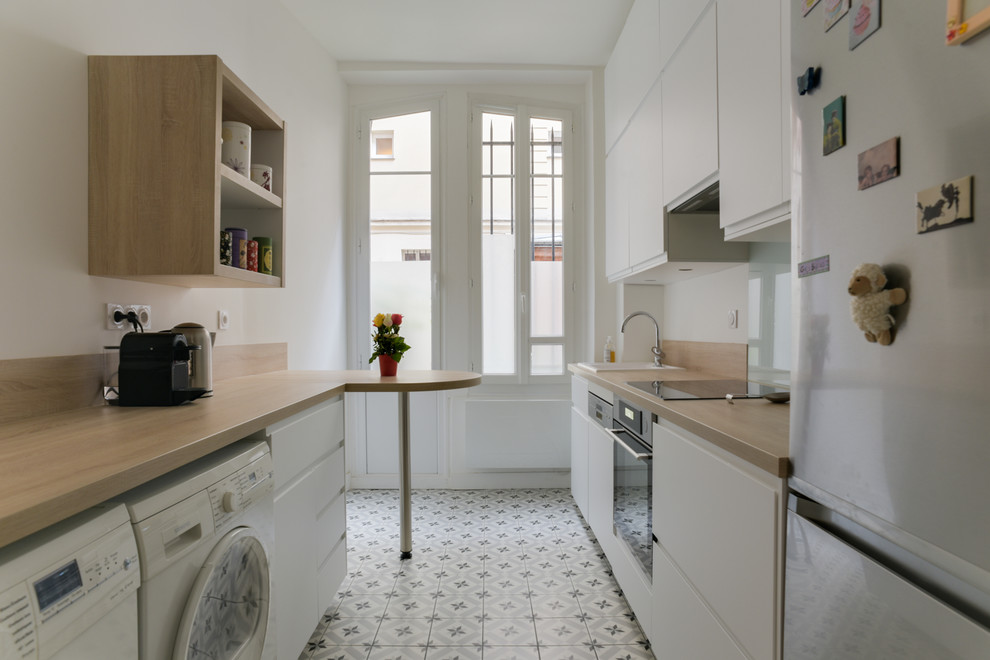 Photo of a small contemporary single-wall enclosed kitchen in Paris with a single-bowl sink, beaded cabinets, white cabinets, wood worktops, beige splashback, wood splashback, integrated appliances, ceramic flooring, grey floors and beige worktops.