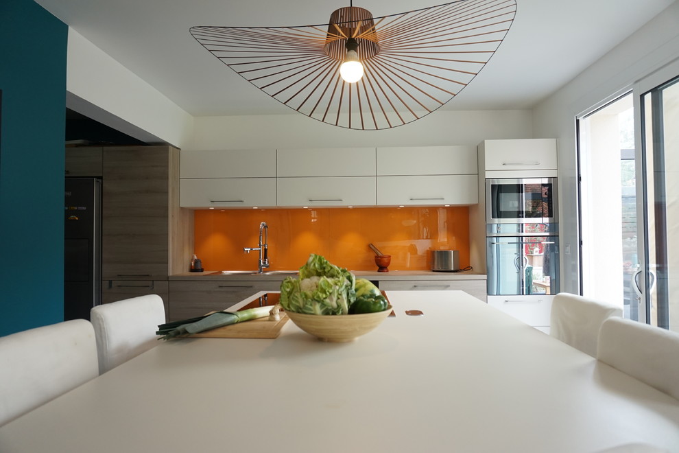 Ispirazione per una grande cucina design chiusa con lavello sottopiano, ante in legno chiaro e paraspruzzi arancione