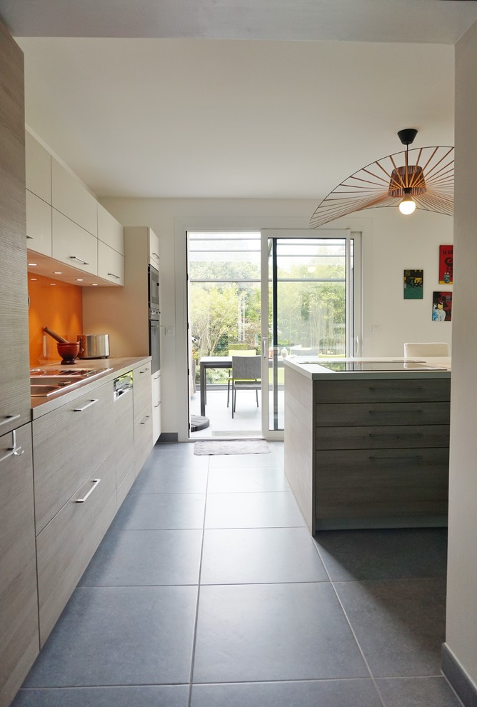 Geschlossene, Zweizeilige, Große Moderne Küche mit Unterbauwaschbecken, hellen Holzschränken, Küchenrückwand in Gelb und Kücheninsel in Paris