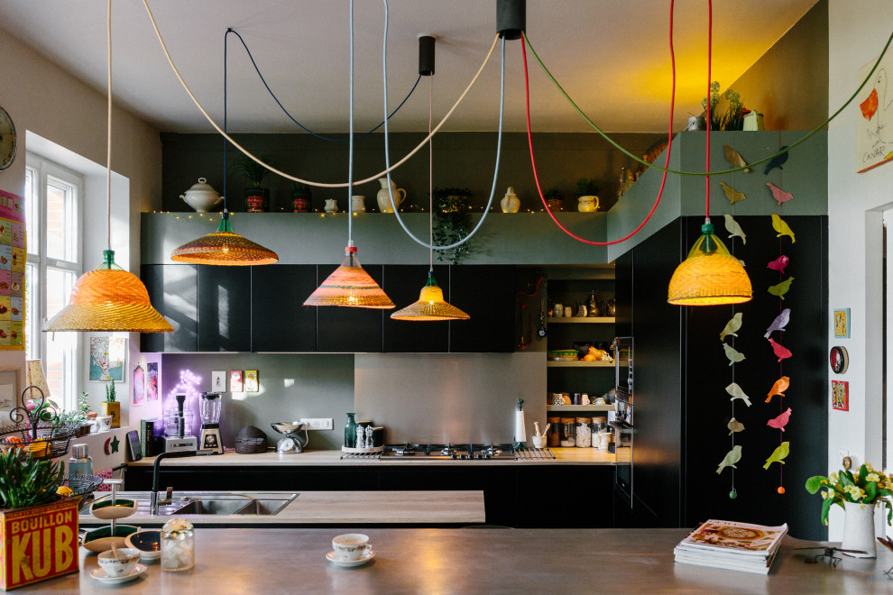 Medium sized eclectic u-shaped kitchen/diner in Nantes with black cabinets, laminate countertops, grey splashback, integrated appliances, an island and a double-bowl sink.