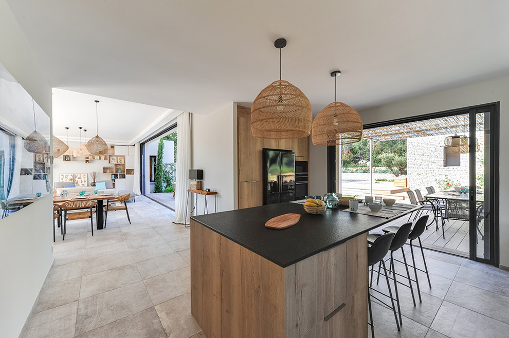 Esempio di una grande cucina minimal con ante in legno chiaro, paraspruzzi nero, pavimento beige e top nero