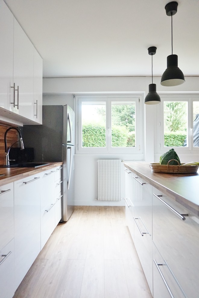 Idéer för att renovera ett stort funkis kök med öppen planlösning, med vita skåp, laminatbänkskiva, brunt stänkskydd, rostfria vitvaror, vinylgolv och en köksö