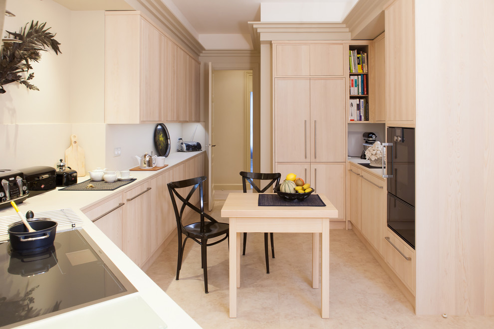 Medium sized modern u-shaped kitchen/diner in Paris with light wood cabinets, quartz worktops, white splashback, flat-panel cabinets, black appliances and no island.