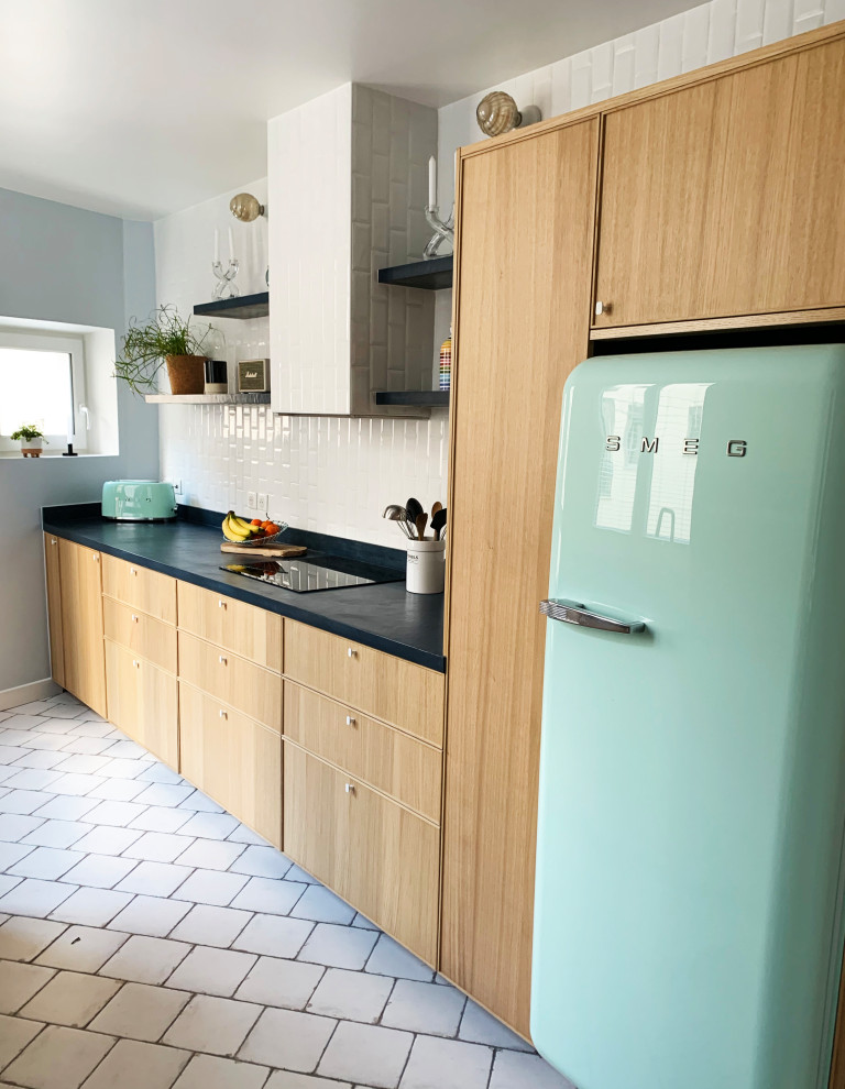 This is an example of a large traditional galley enclosed kitchen in Paris with an integrated sink, beaded cabinets, light wood cabinets, concrete worktops, white splashback, ceramic splashback, stainless steel appliances, ceramic flooring, no island, beige floors and blue worktops.