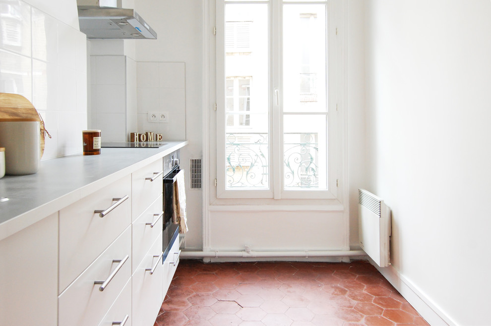 Geschlossene, Einzeilige, Mittelgroße Klassische Küche ohne Insel mit Waschbecken, weißen Schränken, Laminat-Arbeitsplatte, Küchenrückwand in Weiß, rotem Boden und weißer Arbeitsplatte in Paris