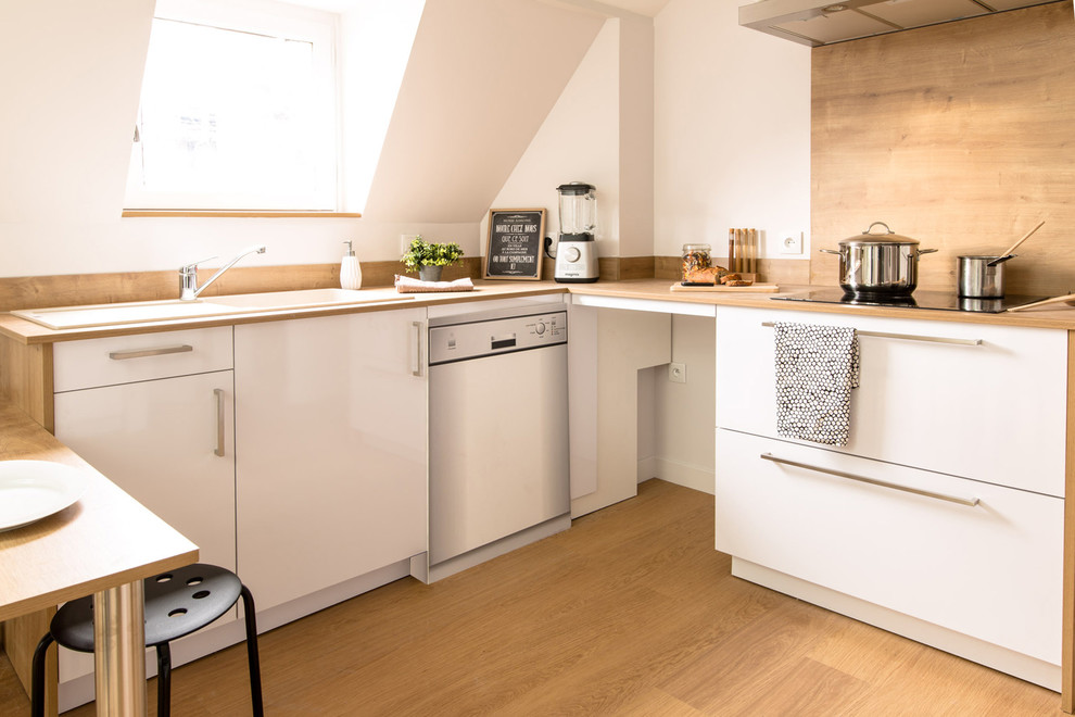 リヨンにある中くらいな北欧スタイルのおしゃれなキッチン (シングルシンク、白いキャビネット、木材のキッチンパネル、シルバーの調理設備、インセット扉のキャビネット、木材カウンター、ベージュキッチンパネル、淡色無垢フローリング、ベージュの床) の写真