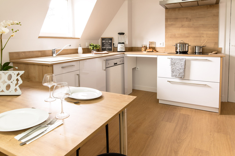 Immagine di una cucina scandinava di medie dimensioni con ante a filo, ante bianche, top in legno, paraspruzzi beige, paraspruzzi in legno, parquet chiaro e pavimento beige