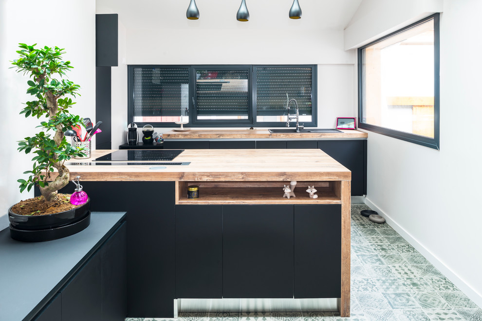 Foto på ett stort funkis kök, med en dubbel diskho, luckor med infälld panel, svarta skåp, träbänkskiva, integrerade vitvaror, klinkergolv i keramik och en köksö
