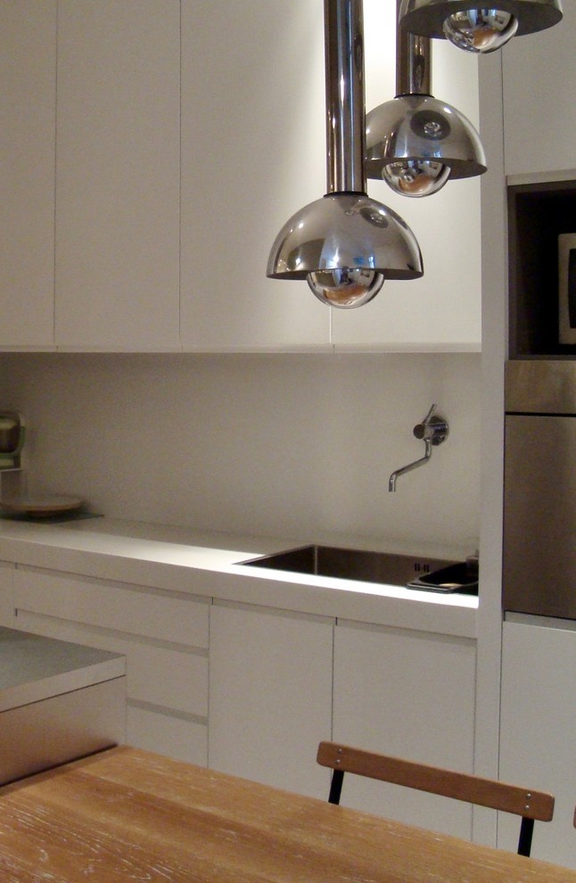 Idéer för ett stort modernt kök, med en undermonterad diskho, luckor med profilerade fronter, vita skåp, bänkskiva i koppar, vitt stänkskydd, rostfria vitvaror, cementgolv, en köksö och grått golv