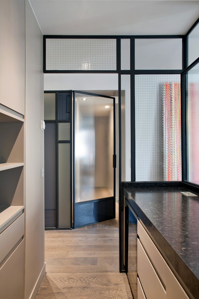 Photo of a contemporary l-shaped enclosed kitchen in Paris with beaded cabinets.