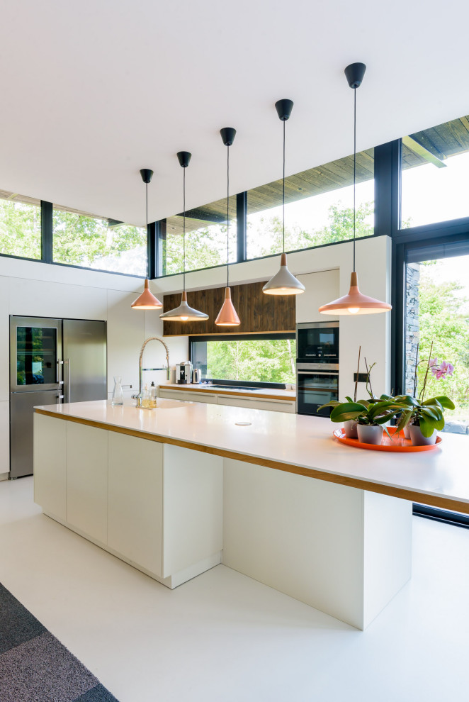 Exempel på ett modernt vit vitt l-kök, med släta luckor, vita skåp, fönster som stänkskydd, rostfria vitvaror, en köksö, vitt golv, en undermonterad diskho, bänkskiva i koppar och betonggolv