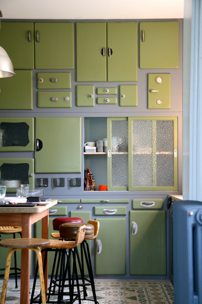 Medium sized bohemian single-wall enclosed kitchen in Paris with green cabinets and an island.