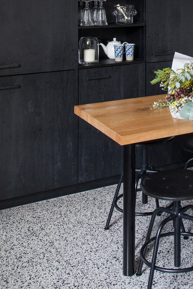 Geschlossene, Mittelgroße Moderne Küche ohne Insel in L-Form mit schwarzen Schränken, Arbeitsplatte aus Holz, Terrazzo-Boden und schwarzer Arbeitsplatte in Paris