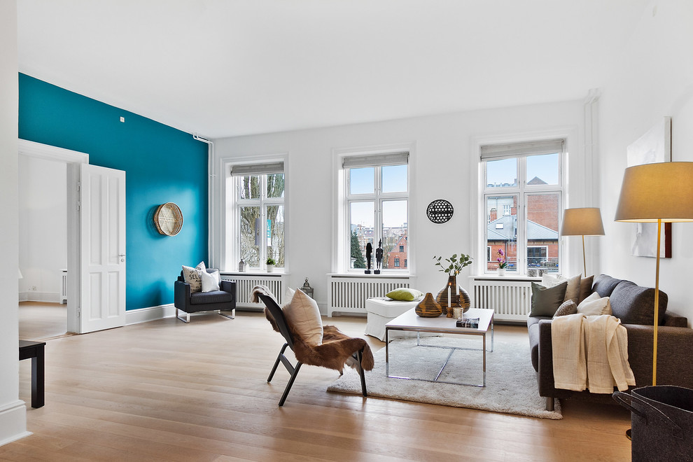 Cette image montre un salon nordique de taille moyenne et ouvert avec un mur bleu, une salle de réception, parquet clair et un sol beige.