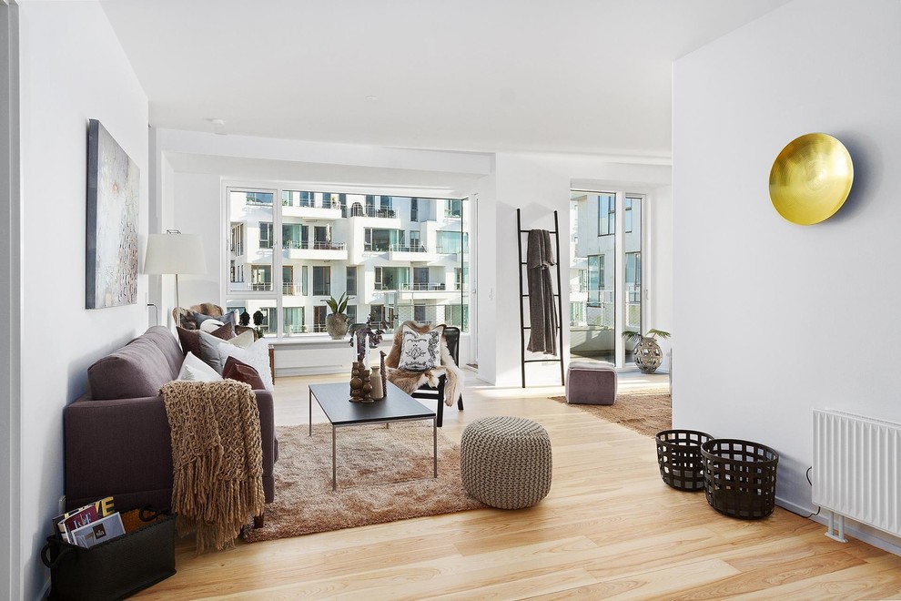 Inspiration for a mid-sized scandinavian open concept light wood floor and brown floor living room remodel in Copenhagen with white walls