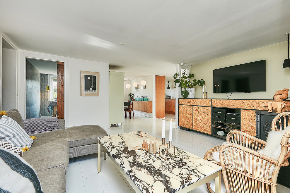 Foto di un soggiorno minimalista con pavimento in legno verniciato e TV a parete