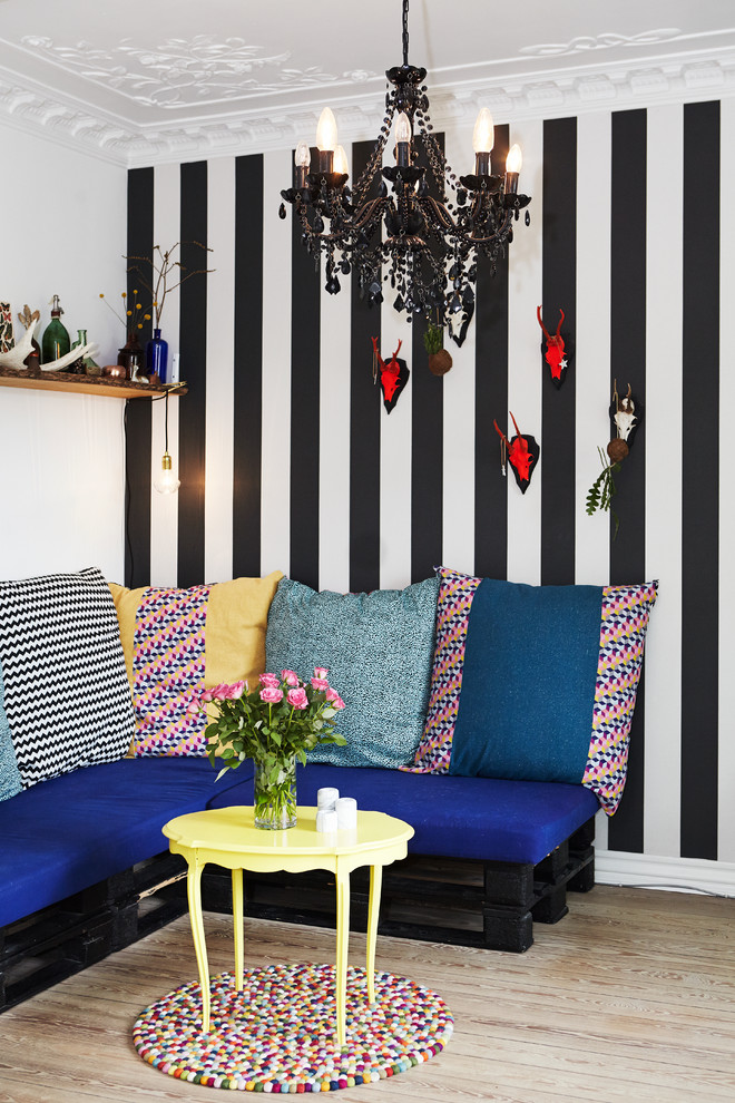 Diseño de salón bohemio con paredes multicolor y suelo de madera clara