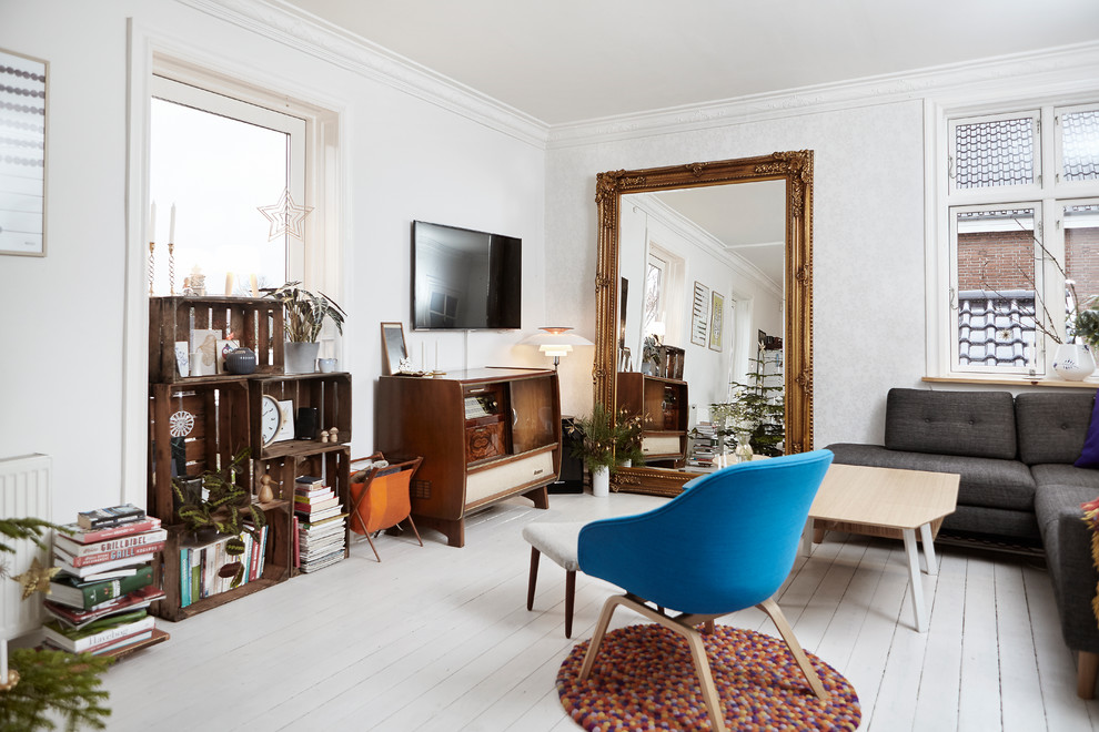 Esempio di un soggiorno eclettico di medie dimensioni e chiuso con pareti bianche, pavimento in legno verniciato, TV a parete e pavimento bianco