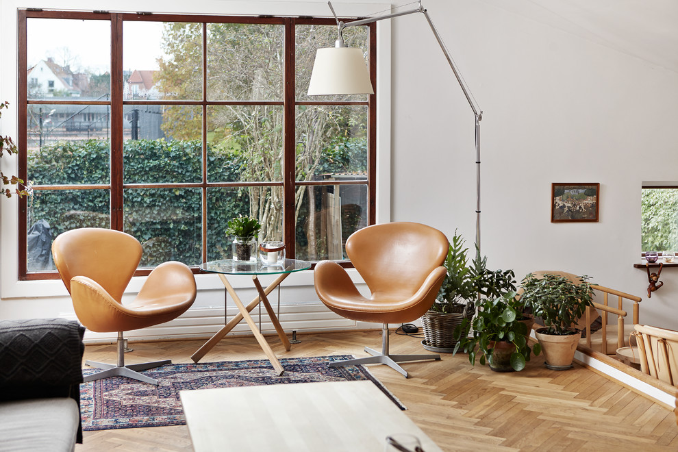 Abgetrenntes Skandinavisches Wohnzimmer mit weißer Wandfarbe, braunem Holzboden und beigem Boden in Aarhus
