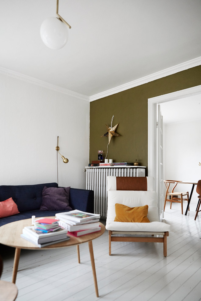 Пример оригинального дизайна: маленькая гостиная комната в скандинавском стиле с зелеными стенами, деревянным полом и акцентной стеной для на участке и в саду