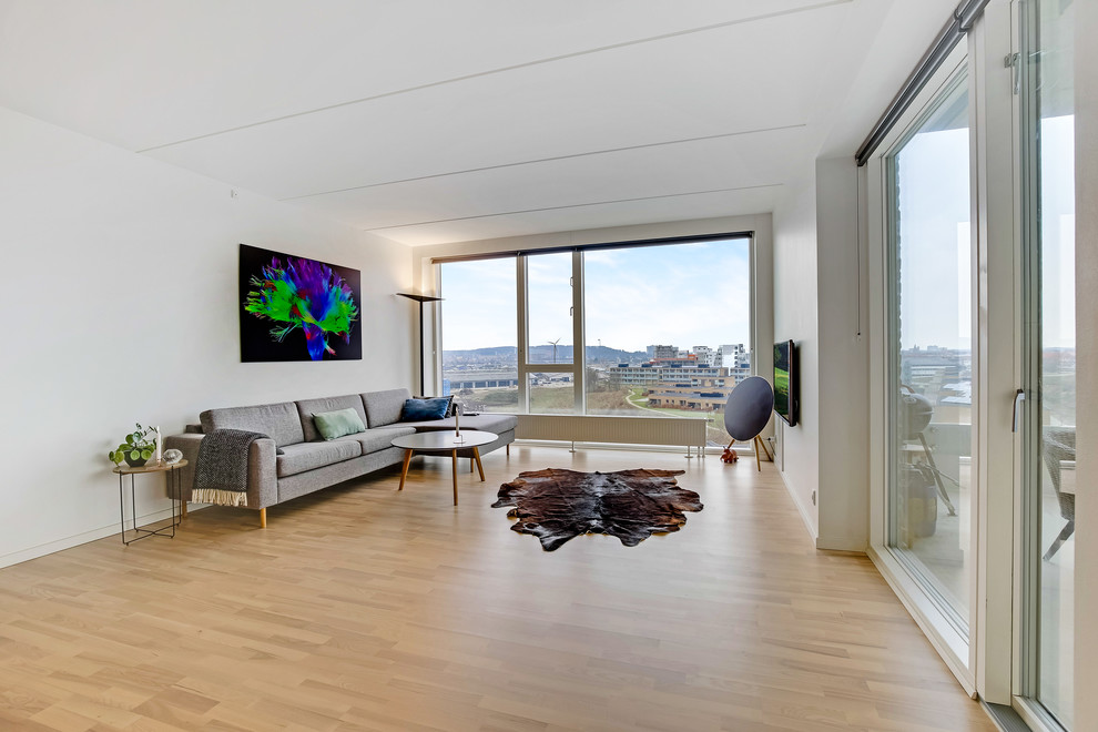 Photo of a medium sized modern living room in Aalborg with white walls and laminate floors.