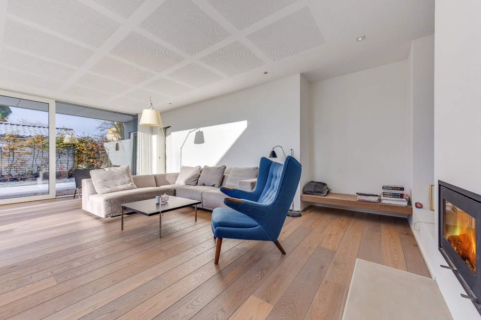 Свежая идея для дизайна: гостиная комната в современном стиле с белыми стенами, стандартным камином и фасадом камина из металла - отличное фото интерьера