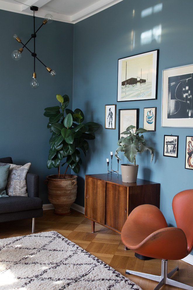 Ejemplo de salón escandinavo con paredes azules y suelo de madera en tonos medios
