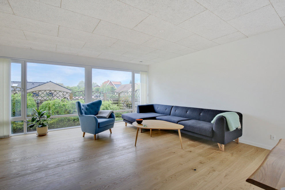Ejemplo de salón abierto escandinavo grande con paredes blancas y suelo de madera en tonos medios